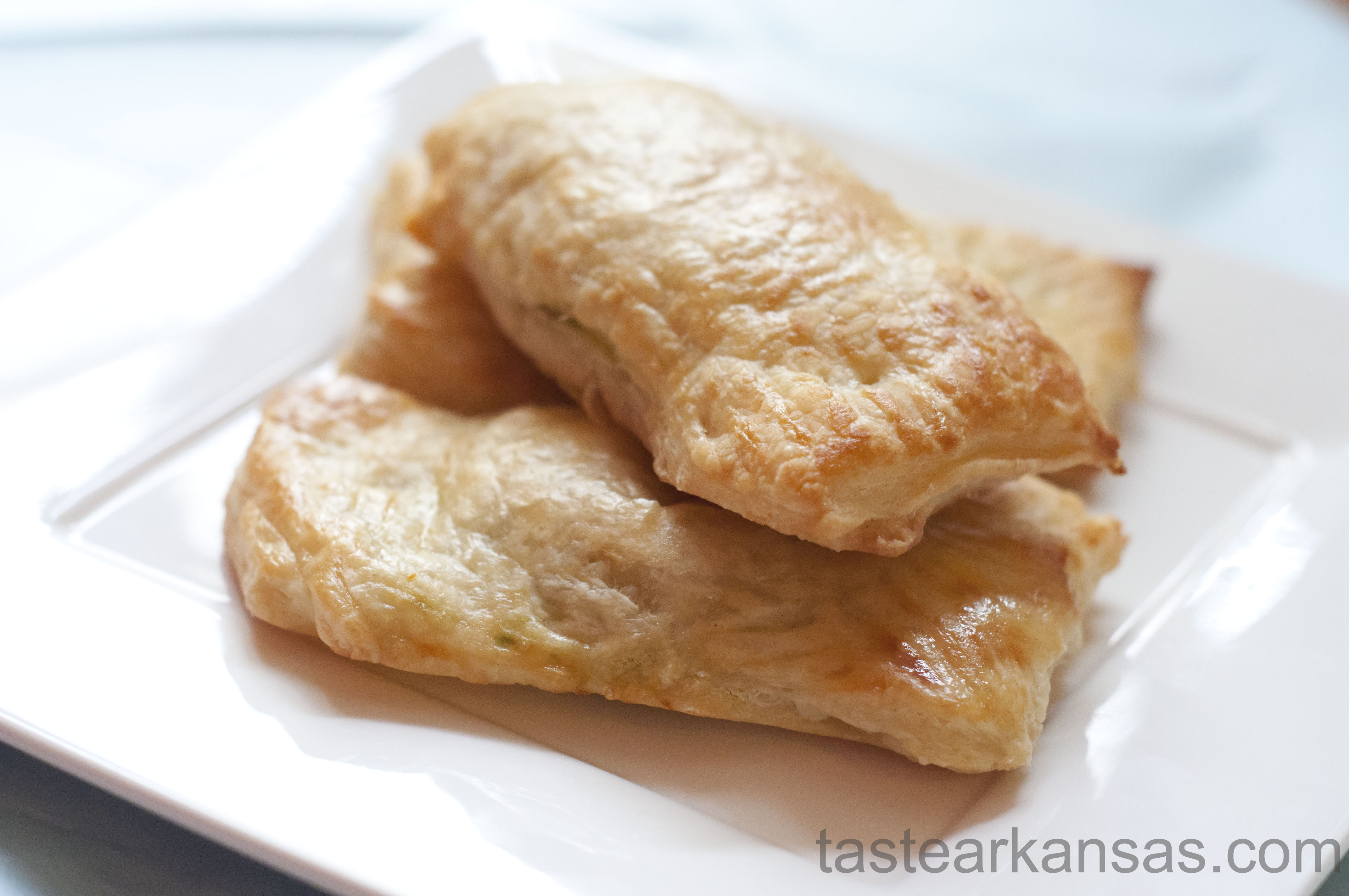 This picture shows a lightly browned, puff pastry packet that is filled with a warm mixture of avocado, cream cheese and salsa. The edges are brown and the pastry is buttery, flaky and delicious.