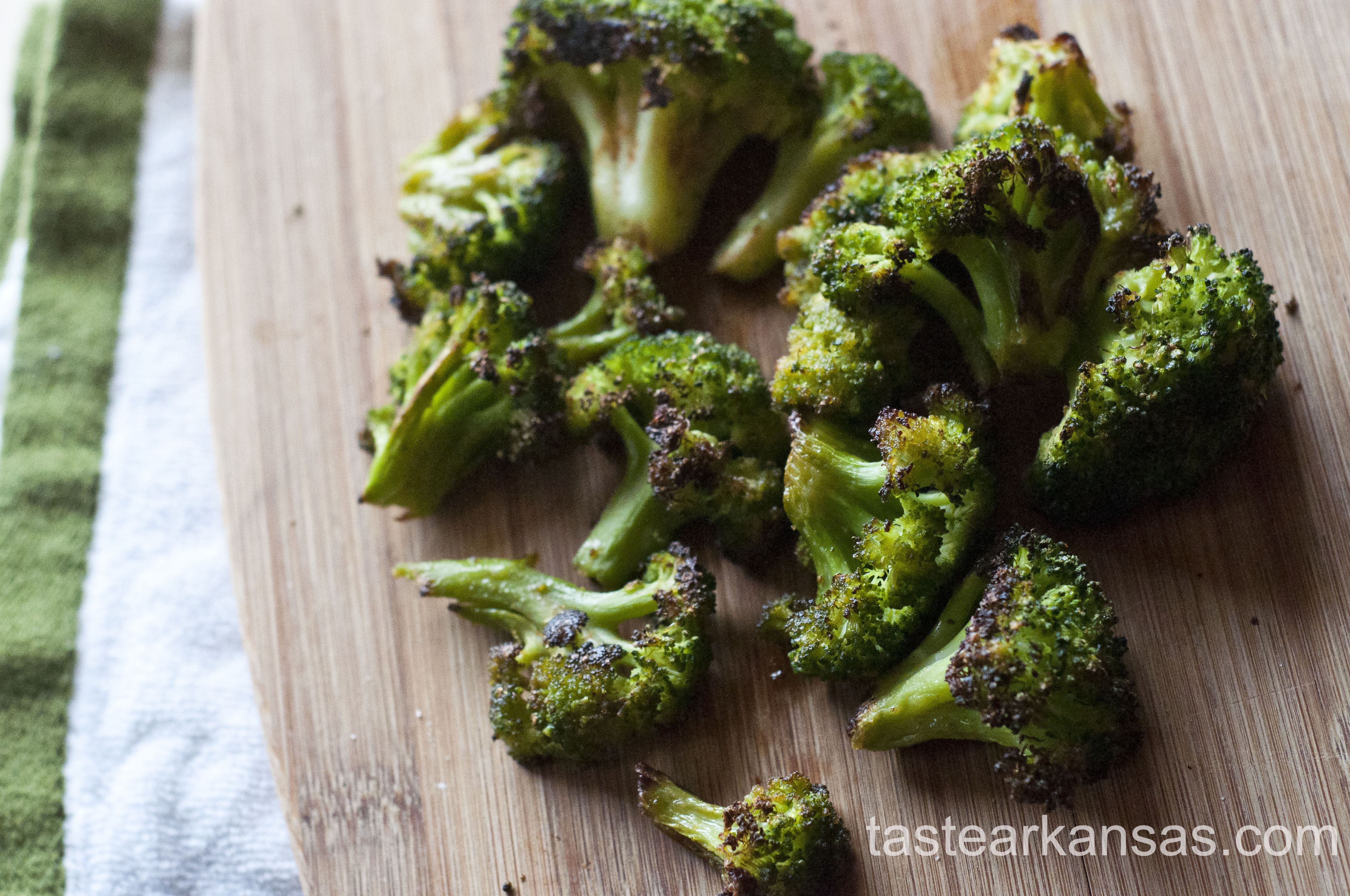 this image is of roasted broccoli florets on a cutting board in natural light