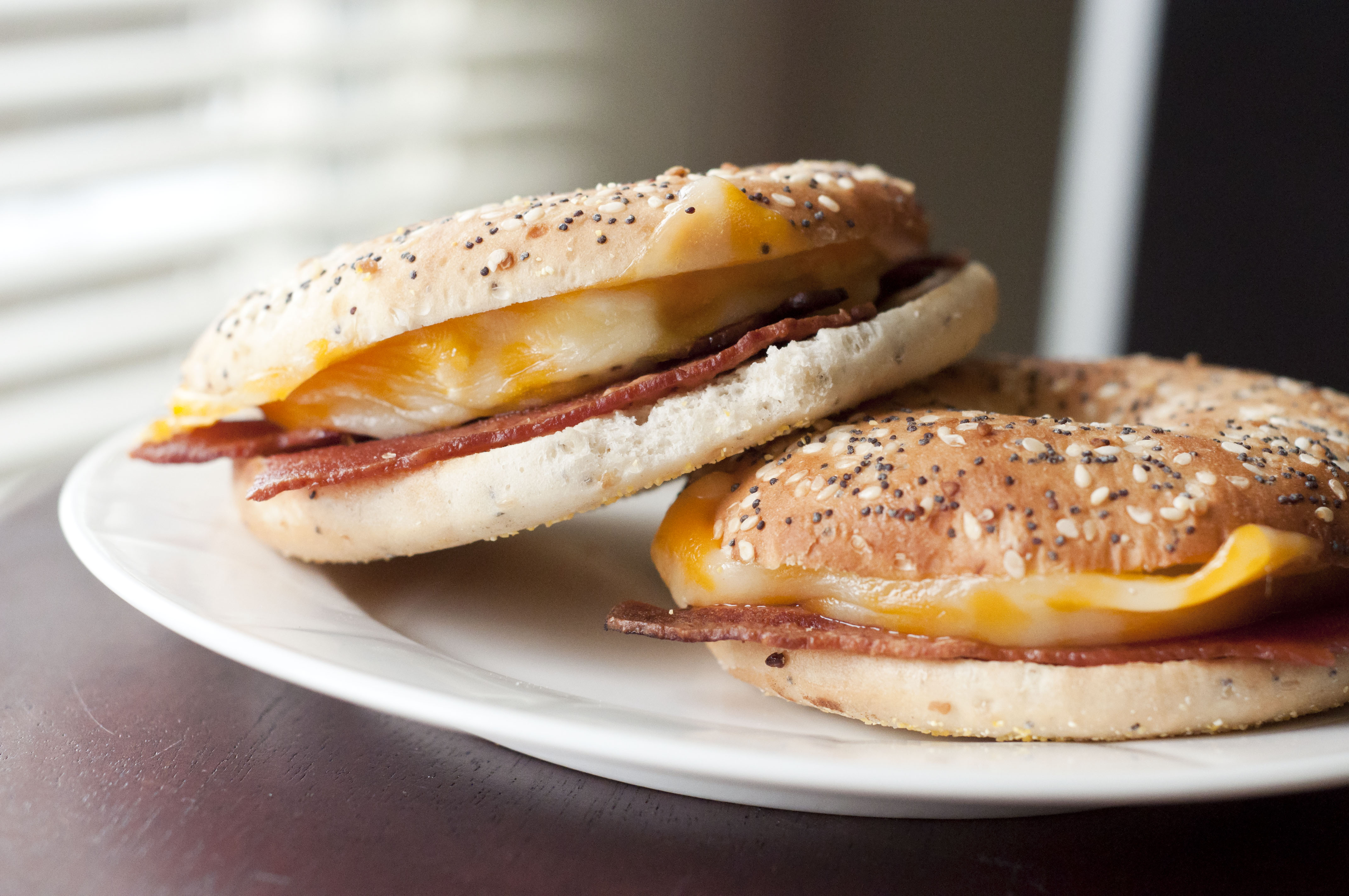 a plate of warm, homemade bacon, egg and cheese bagel sandwiches